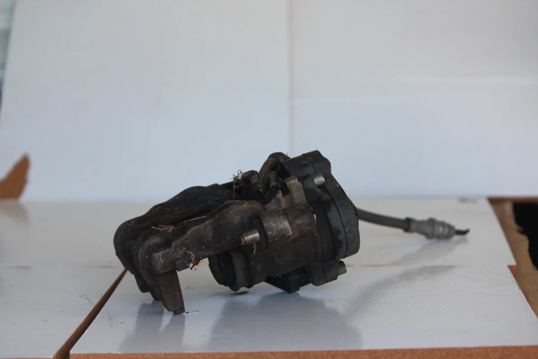 Rear brake caliper with electronic parking brake actuator